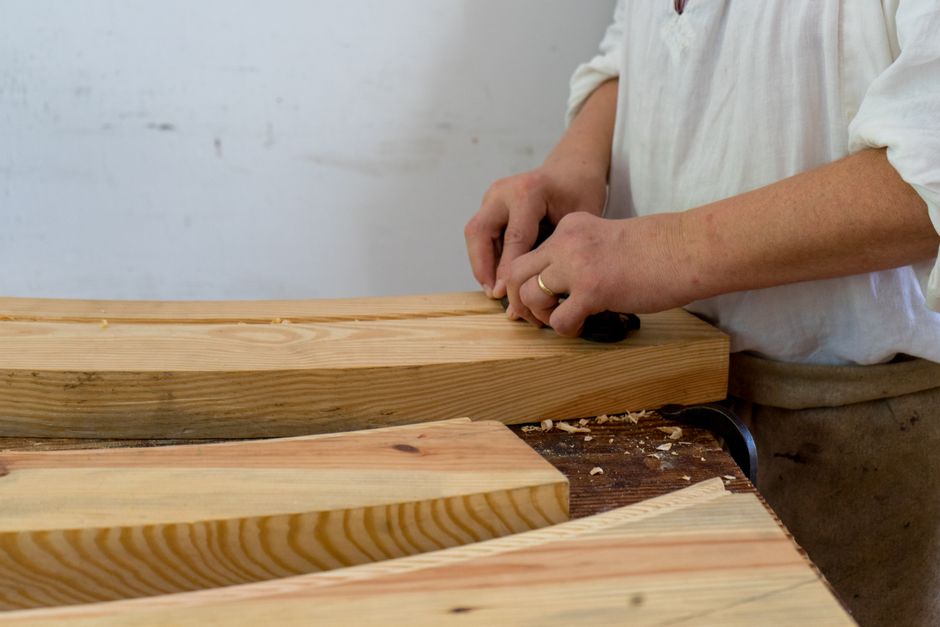 Woodworker meticulously crafting a piece of bespoke furniture in a workshop